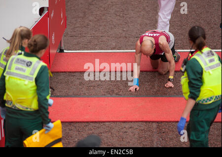 The Mall, London, UK. 26th April, 2015. A runner crawls over the line finishing the Virgin Money 2015 London Marathon Club, Charity and Ballot race. Credit:  Malcolm Park editorial/Alamy Live News Stock Photo