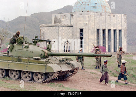 Afghan mujahideen fighters with Jamayat-E-Islami and a captured government Soviet made T-62 tank as they approach the capital April 18, 1992 in Kabul, Afghanistan. The Jamayat-E-Islami were the first to enter Kabul and took control of most of the strategic buildings in the city. Stock Photo