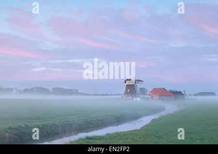 Dutch windmill in dense morning fog, Holland Stock Photo