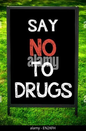 SAY NO TO DRUGS  message on sidewalk blackboard sign against green grass background. Copy Space available. Concept image Stock Photo