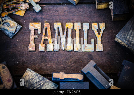 The word FAMILY written in rusted metal letters surrounded by vintage wooden and metal letterpress type. Stock Photo