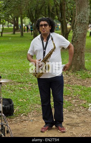 SAO PAULO, BRAZIL - FEBRUARY 01, 2015: An unidentified street musician playing saxophone in the Ibirapuera Park at Sao Paulo Bra Stock Photo