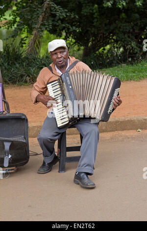 SAO PAULO, BRAZIL - FEBRUARY 01, 2015: An unidentified street musician singing and playing one old accordion in the Ibirapuera P Stock Photo