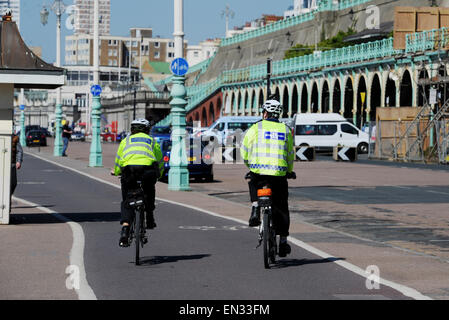 Two Police Community Support Officers cycling along Brighton seafront April 2015 Stock Photo