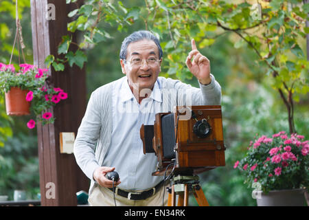The old man is using old-fashioned camera Stock Photo