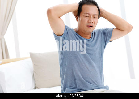 A headache middle-aged man in the bedroom Stock Photo