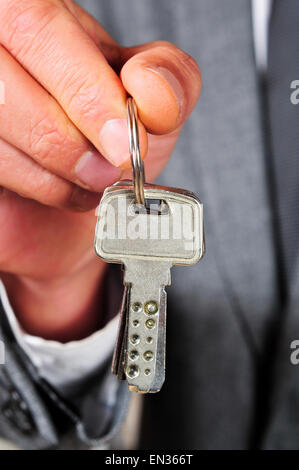 a man wearing a suit with a key ring in his hand Stock Photo