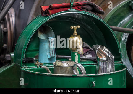 An old brass oil tap with cans in an engineer workshop. Stock Photo