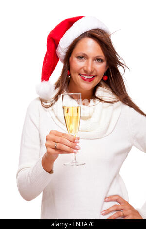 Playful woman wearing a festive red Santa hat and holding a flute of champagne celebrating Christmas blowing a kiss across the p Stock Photo