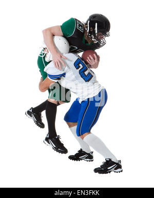 Two male players of American football fighting for ball, studio shot