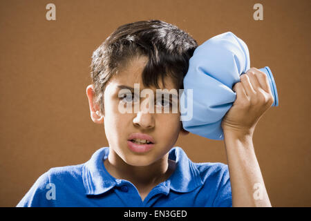 Boy holding ice pack to head Stock Photo