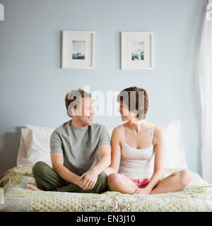 couple sitting on their bed Stock Photo