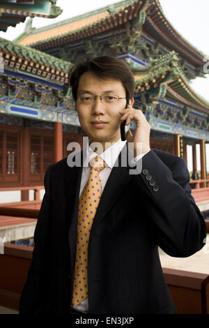 Businessman on cell phone in Asia smiling Stock Photo