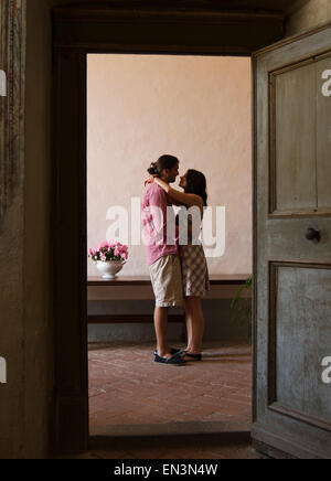 Italy, Tuscany, Young couple kissing in old house Stock Photo
