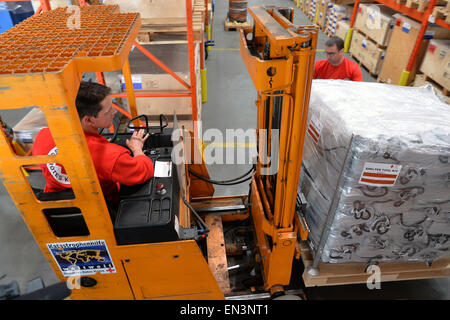 Schoenefeld, Germany. 27th Apr, 2015. A member of the German Red Cross (DRK) in a forklift transports boxes containing relief supplies for the victims of the earthquake in Nepal at the DRK logistics center in Schoenefeld, Germany, 27 April 2015. The departure of a DRK aid flight to Kathmandu is scheduled for tonight. Photo: Bernd Settnik/dpa/Alamy Live News Stock Photo