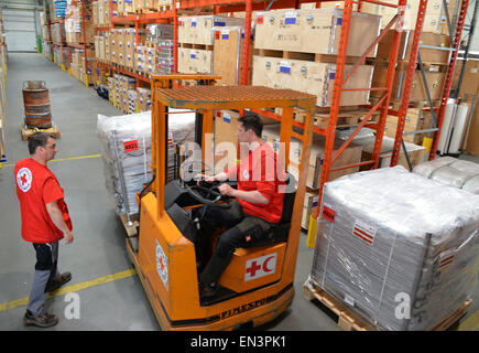 Schoenefeld, Germany. 27th Apr, 2015. A member of the German Red Cross (DRK) in a forklift transports boxes containing relief supplies for the victims of the earthquake in Nepal at the DRK logistics center in Schoenefeld, Germany, 27 April 2015. The departure of a DRK aid flight to Kathmandu is scheduled for tonight. Photo: Bernd Settnik/dpa/Alamy Live News Stock Photo