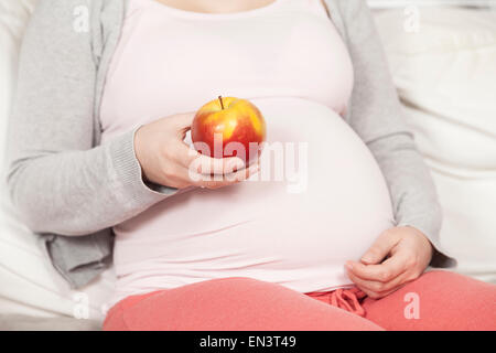 Pregnant holding a red apple Stock Photo