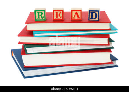 Stack of generic hardback books with word READ spelt with letter blocks on top of a book pile to illustrate a reading concept isolated on white. UK Stock Photo