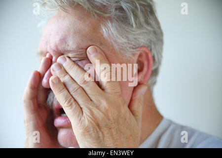 A senior man experiencing stuffy nose, clogged sinuses and headache of a bad flu or cold Stock Photo