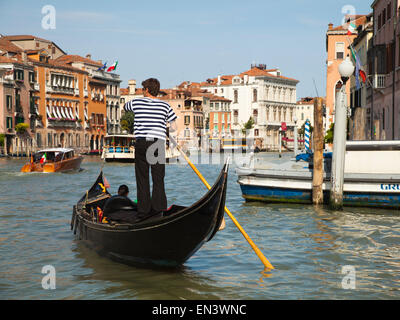 Italy, Venice, Young woman traveling in gondola on canal Stock Photo