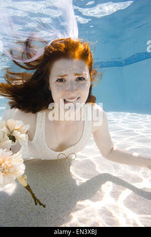 Young woman underwater, wedding dress and red hair Stock Photo - Alamy