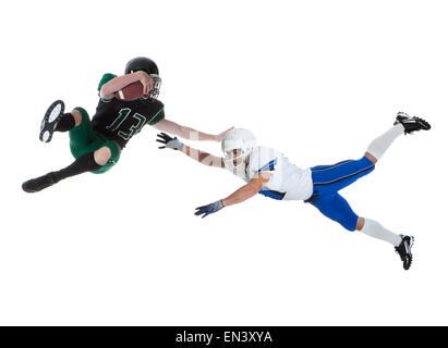 Two male players of American football fighting for ball, studio shot Stock Photo