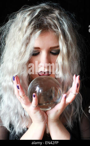 Beautiful young woman holding a crystal ball Stock Photo