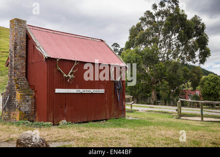 Red tin shed with brickwork chimney on Petuna farm, New Zealand. Stock Photo
