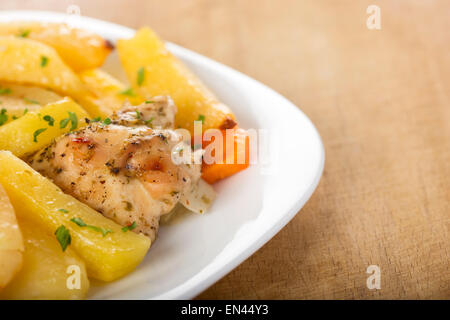 Roasted chicken with potatoes and herbs on white plate Stock Photo