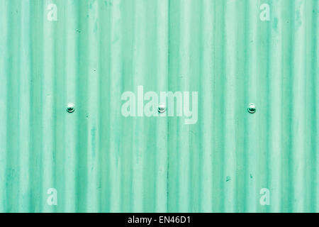 Part of a metal wall made from corrugated metal painted green Stock Photo