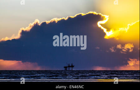 Ainsdale, Southport, Merseyside, UK. 27th April, 2015. UK Weather.  Colourful sunset over Morecambe Bay Gas Rig. In 1974 the second largest gas field in the UK was discovered 25 miles (40 km) west of Blackpool, with original reserves of over 7 trillion cubic feet (tcf) (200 billion cubic metres). At its peak 15% of Britain's gas supply came from the bay but production is now in decline and the main field was mothballed in 2011. Stock Photo