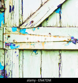 The hinge of a weathered green wooden gate Stock Photo