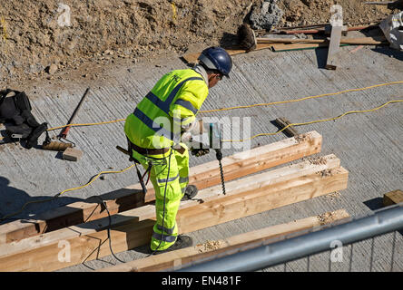 a construction worker using a large electric drill Stock Photo