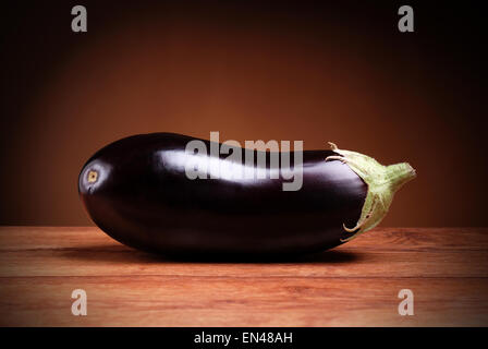 eggplant isolated on wood table and brown background Stock Photo