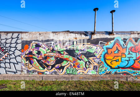 Saint-Petersburg, Russia - April 6, 2015: Colorful graffiti painted on old gray concrete garage walls Stock Photo