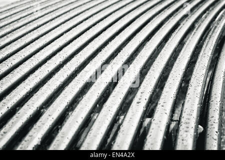 Metal bars on a modern bench with rain drops Stock Photo