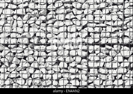 Stone wall made of rocks in wire cages Stock Photo