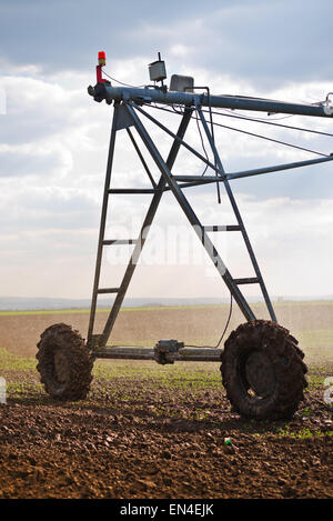 Automated Farming Irrigation Sprinklers System in Operation on Cultivated Agricultural Field Stock Photo