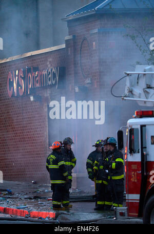 Baltimore, USA. 27th Apr, 2015. Fire fighters work near a CVS pharmacy store which was set ablaze in Baltimore, Maryland, the United States, April 27, 2015. Maryland governor Larry Hogan Monday evening declared a state of emergency and activated the National Guard to address the escalating violence and unrest in Baltimore City following the funeral of a 25-year-old black man who died after he was injured in police custody. Credit:  Yin Bogu/Xinhua/Alamy Live News Stock Photo