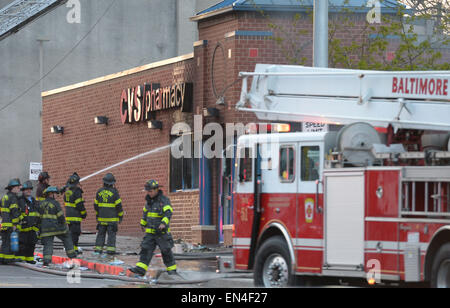 Baltimore, USA. 27th Apr, 2015. Fire fighters work near a CVS pharmacy store which was set ablaze in Baltimore, Maryland, the United States, April 27, 2015. Maryland governor Larry Hogan Monday evening declared a state of emergency and activated the National Guard to address the escalating violence and unrest in Baltimore City following the funeral of a 25-year-old black man who died after he was injured in police custody. Credit:  Yin Bogu/Xinhua/Alamy Live News Stock Photo