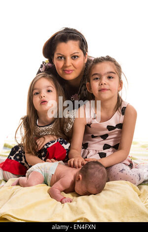 Mother posing with her three girls daughters against white background Stock Photo