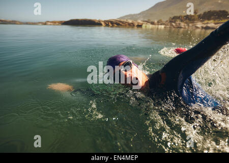 Open water swimming. Male athlete swimming in lake. Triathlon long distance swimming. Stock Photo