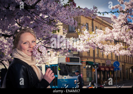 A young, cute, girl under blossoming cherry trees at Järntorget in Gothenburg, Sweden. Stock Photo