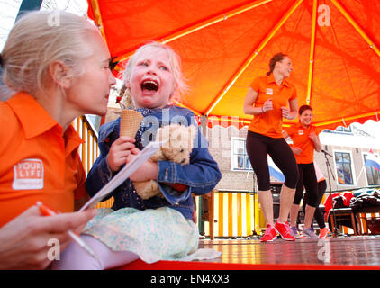 Voorschoten, Netherlands. 27th, April 2015. A young girl is seen crying next to a dancing event during King’s Day celebrations. The annual celebration is popular in The Netherlands and the royal family enjoys wide support although several groups of people calling themselves republicans are calling for an end of the reign of the royal family and their political activities. Credit:  Jaap Arriens/Alamy Live News Stock Photo