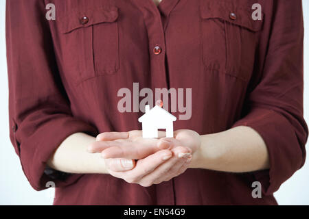 Woman Holding Model House In Palm Of Hand Stock Photo