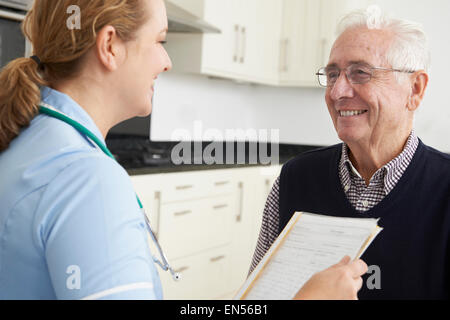 Nurse Discussing Medical Record With Senior Male Patient Stock Photo