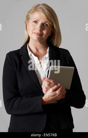 Portrait Of Mature Businesswoman Holding Digital Tablet Stock Photo