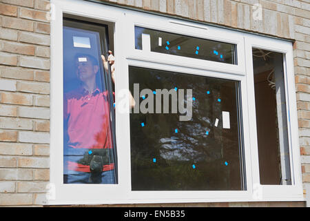 Construction Worker Installing New Windows In House Stock Photo