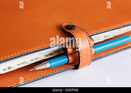 Natural tan leather Filofax diary closed with dividers and a blue pencil Stock Photo