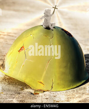 angel sitting on a helmet, used in war, Stock Photo